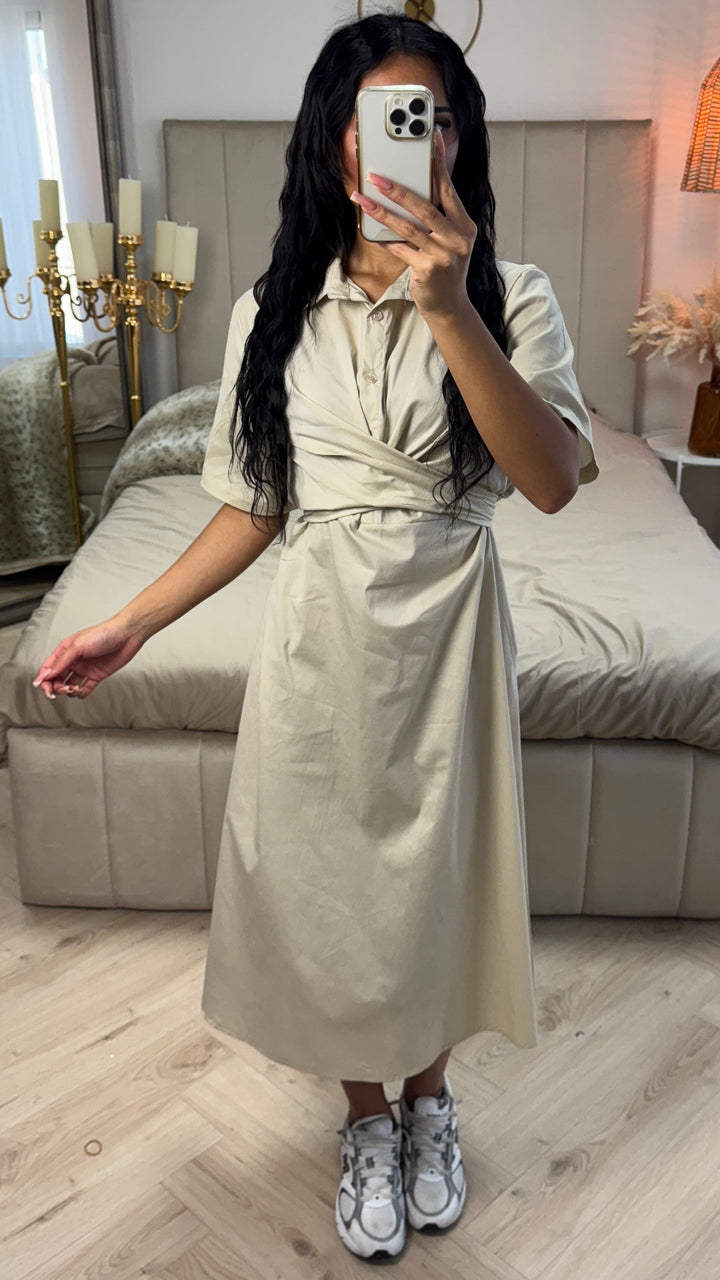 Front view, worn by model, a beige cross tie belt blouse dress in soft cotton blend with a phone covering her face