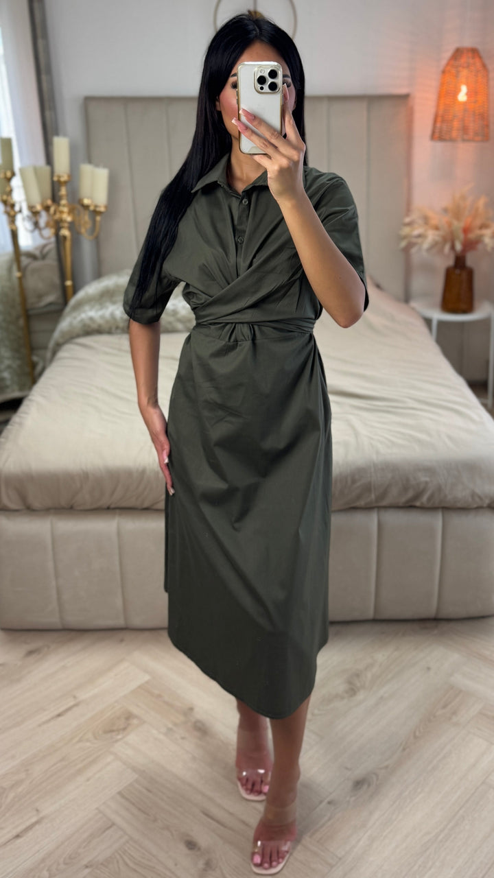 Front view, worn by model, a khaki green cross tie belt blouse dress in soft cotton blend with a phone covering her face