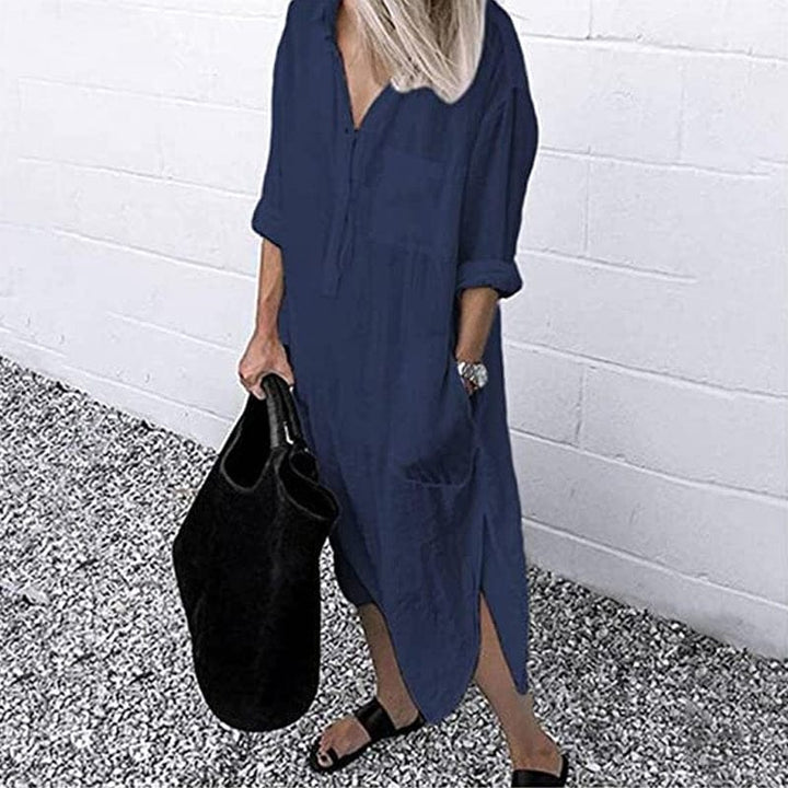 Front view of a model wearing the navy elegant solid colour slit shirt dress with a black tote bag and sandals