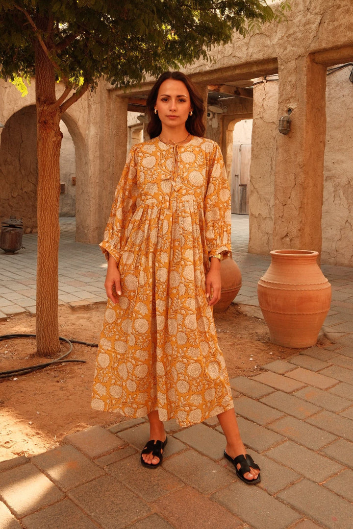 Bohemian Midi Dress, front view worn by model, in mustard yellow with white floral print, long puff sleeves
