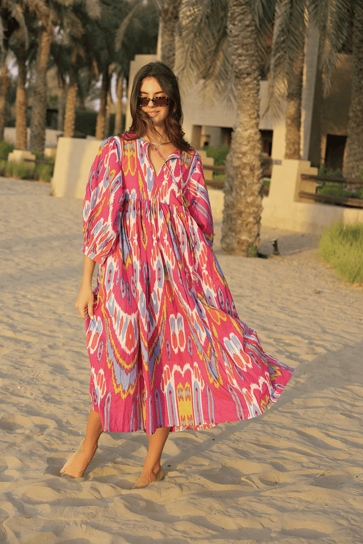 Hot pink ikat print bohemian midi dress worn barefoot on sand