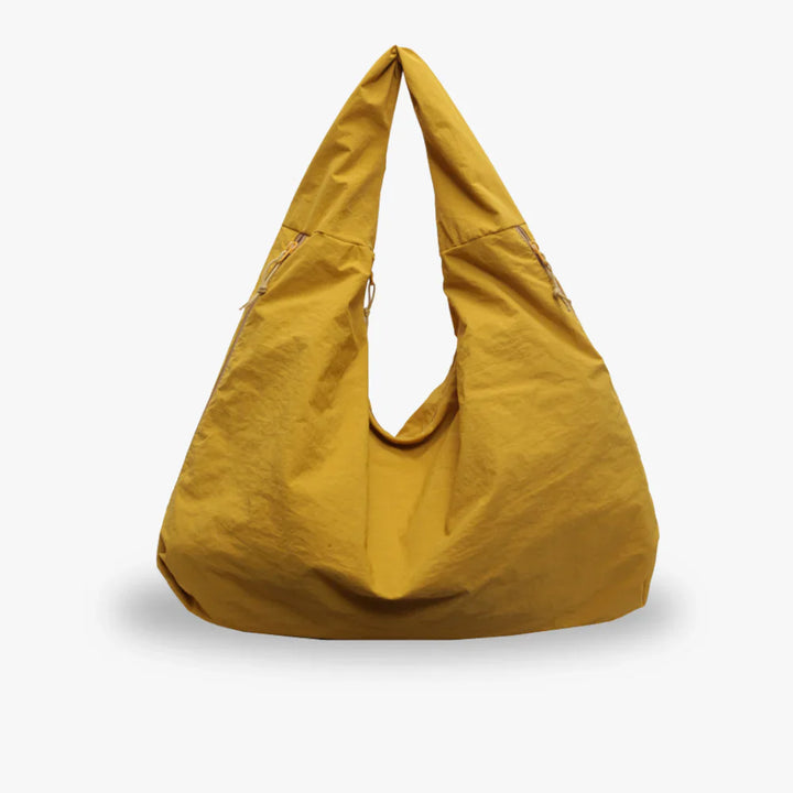 Front view of a mustard recycled nylon hobo bag with a spacious, slouchy design and zip details