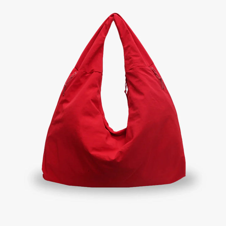 Front view of a red recycled nylon hobo bag with a spacious, triangular design and drawstring details