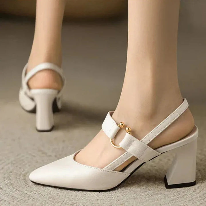 Three quarter view worn by model, white orthopaedic slingback heels with a gold buckle and supportive block heel