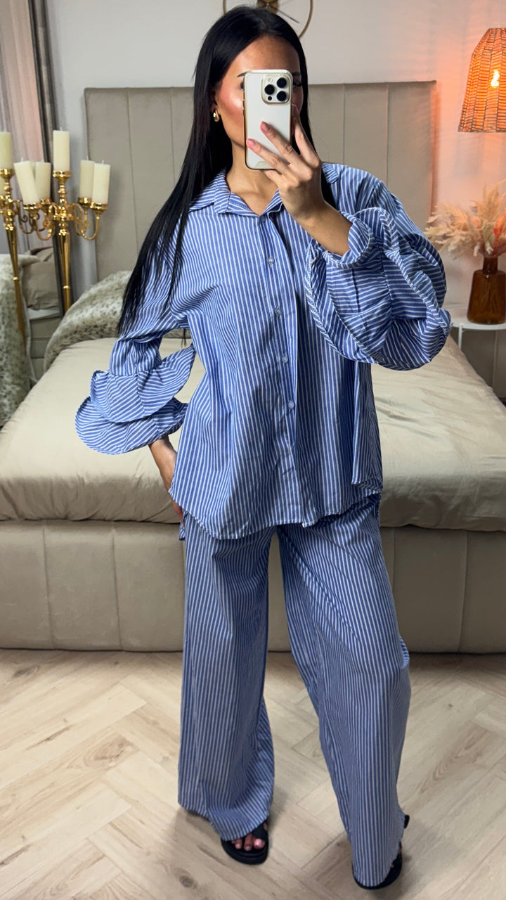 Front view of a model wearing the striped cotton set with ruffle sleeves, standing with one hand in her pocket
