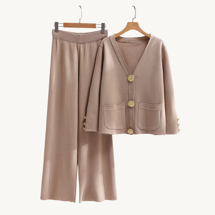 Flat lay of a luxurious knitwear set in beige, featuring a cardigan with gold buttons and wide leg trousers