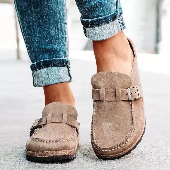 Close up worn by model of light brown suede loafers with buckle and white stitching detail