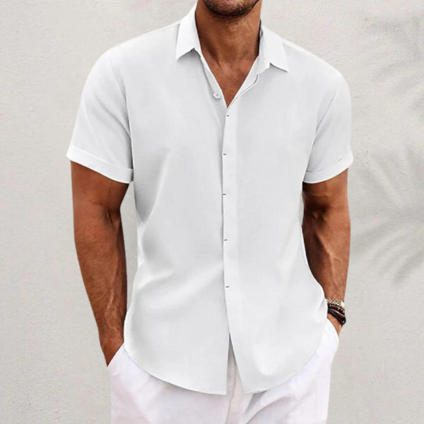 Front view of a man wearing a white relaxed fit linen shirt with short rolled sleeves and white pants