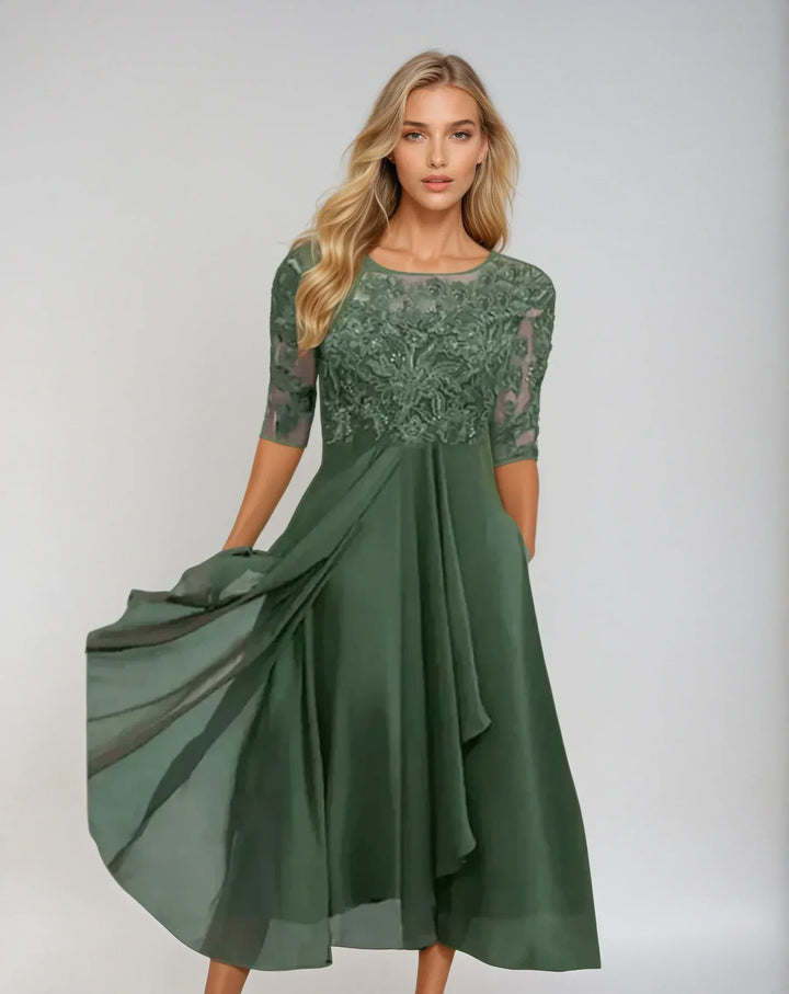 Front view of an elegant chiffon lace long dress with a flowing skirt and embroidered bodice worn by model