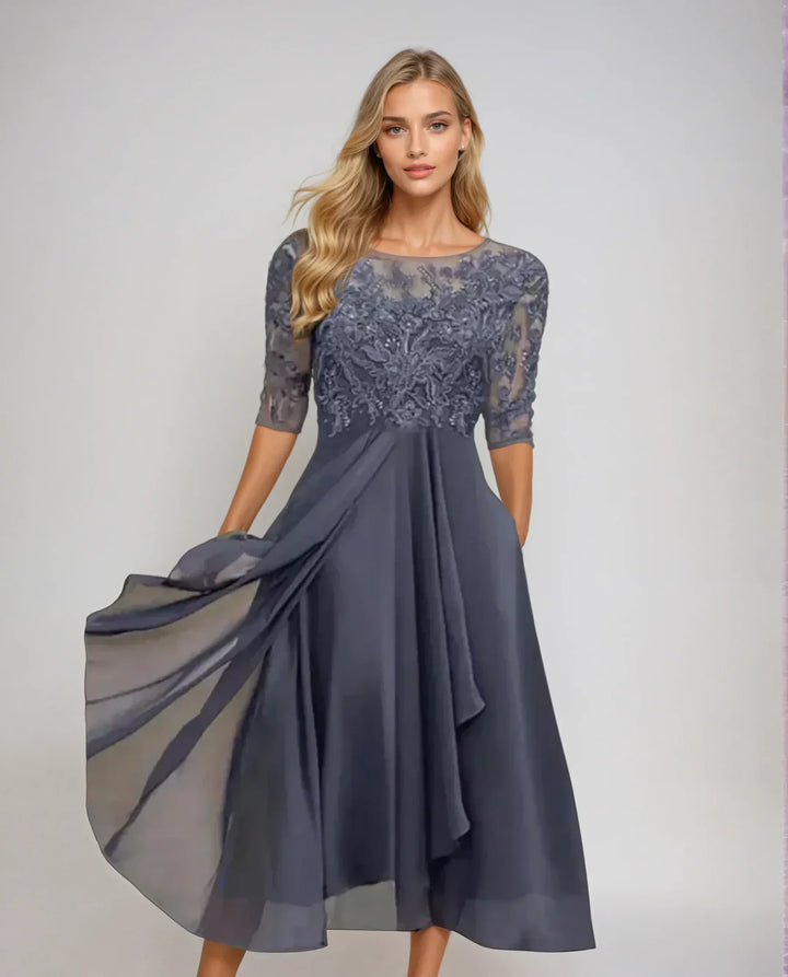 Front view of a model wearing an elegant chiffon lace long dress with a full skirt and sheer overlay