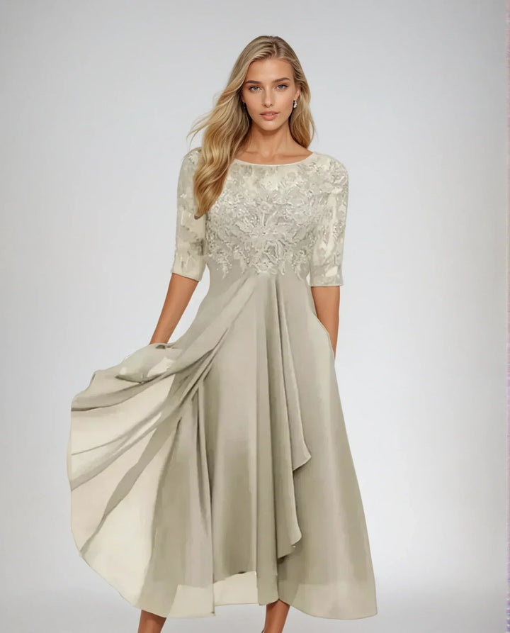 Front view of a model in an elegant chiffon lace long dress with a flowing skirt and embroidered bodice