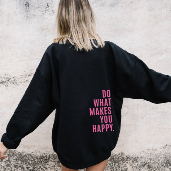 Back view, model in a black relaxed knit pullover hoodie with "DO WHAT MAKES YOU HAPPY" text, close up