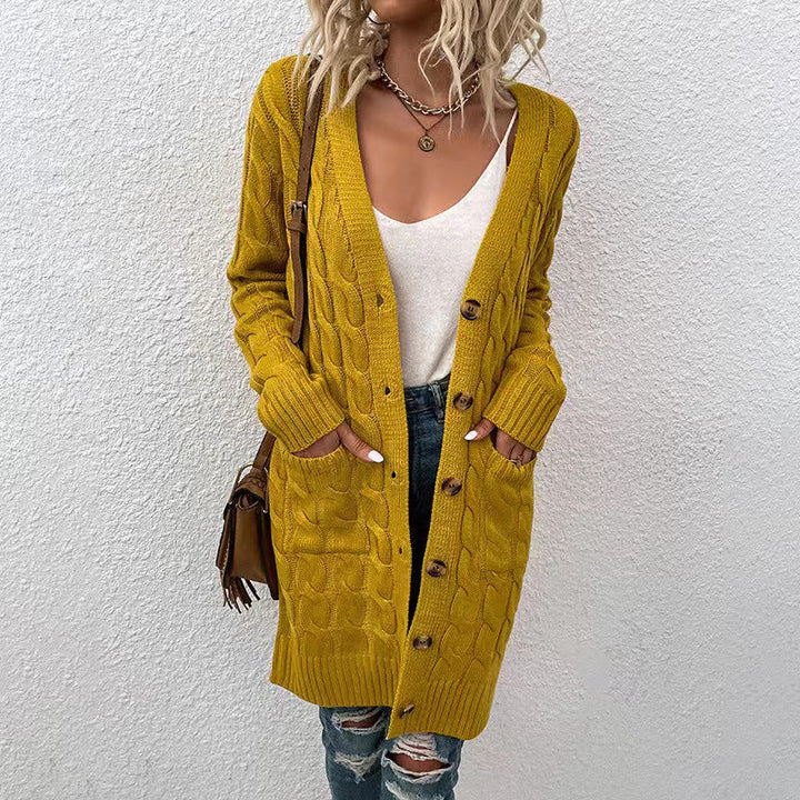 Close up of a model in a mustard yellow cable knit cardigan with large buttons, pockets, and ribbed cuffs