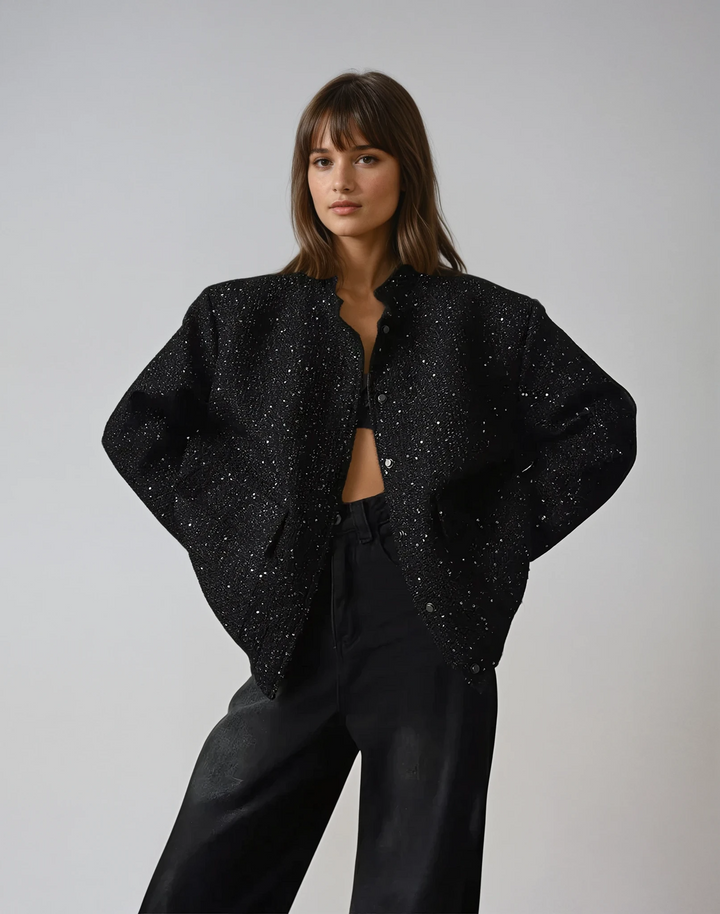 Front view, model wearing open Lucia sequin jacket over a bralette and black jeans