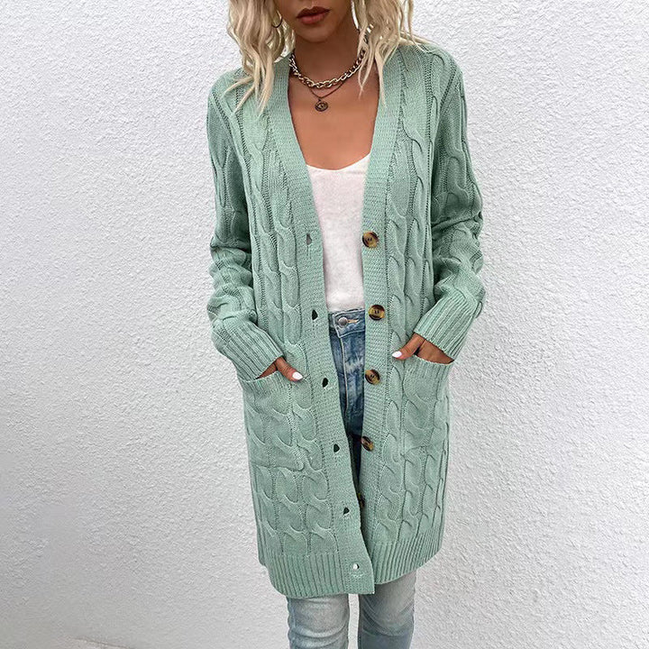 Front view of a model in a long mint green cable knit cardigan with large buttons, pockets, and ribbed cuffs