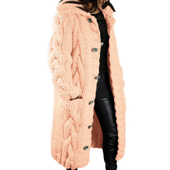 Side view, model wearing a long peach oversized wool blend cardigan with chunky cable knit, hood and buttons