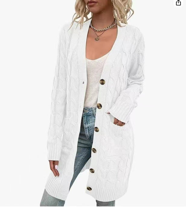 Front view of a model in a long white cable knit cardigan with large buttons, pockets, and ribbed cuffs