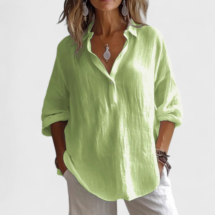 Front view, worn by model, of a light green cotton-blend oversized blouse with rolled-up sleeves and a v-neck collar