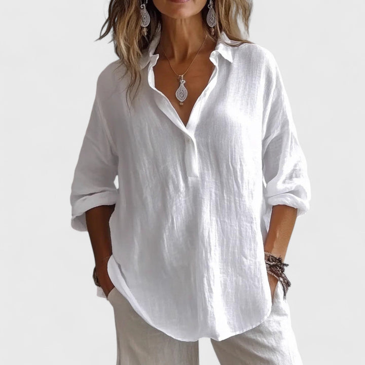 Front view, worn by model, of a white cotton-blend oversized blouse with rolled-up sleeves and a v-neck collar