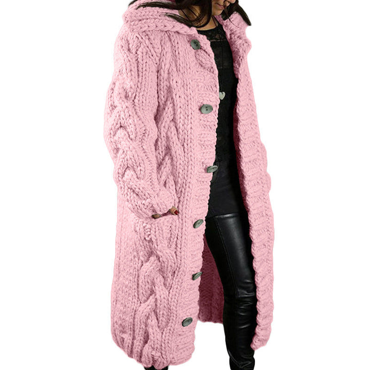 Front view, model wearing a long pink oversized wool blend cardigan with chunky cable knit and grey buttons