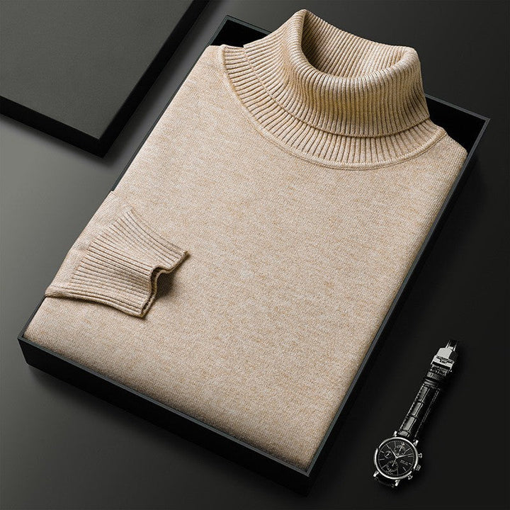 Flat lay of a folded beige premium cashmere knitted collar jumper in a black box with a watch