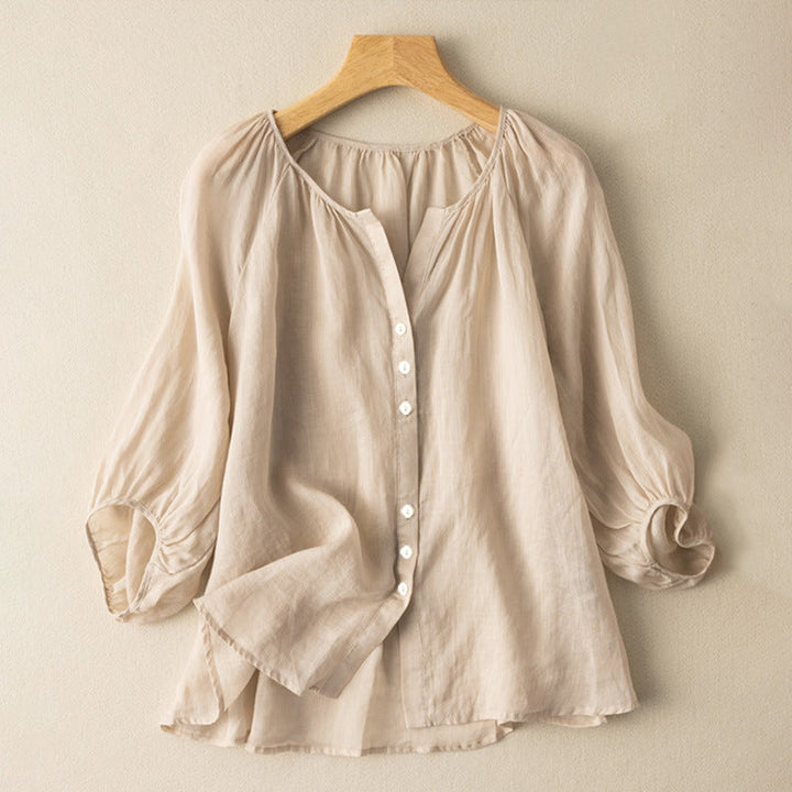 Front view of a lightweight linen blouse in natural on a hanger, showing elegant ruching and buttons