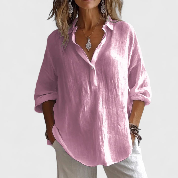 Front view, worn by model, of a pink cotton-blend oversized blouse with rolled-up sleeves and a v-neck collar