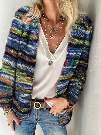 Worn by model, showing the colourful Icelandic pattern sweater over a white top with a belt and jeans