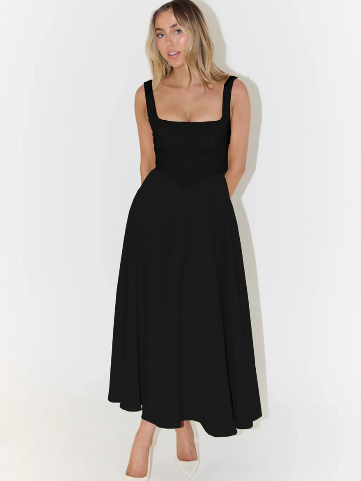 Elegant long dress front view worn by model, square neckline, full skirt, hands behind back, looking at camera
