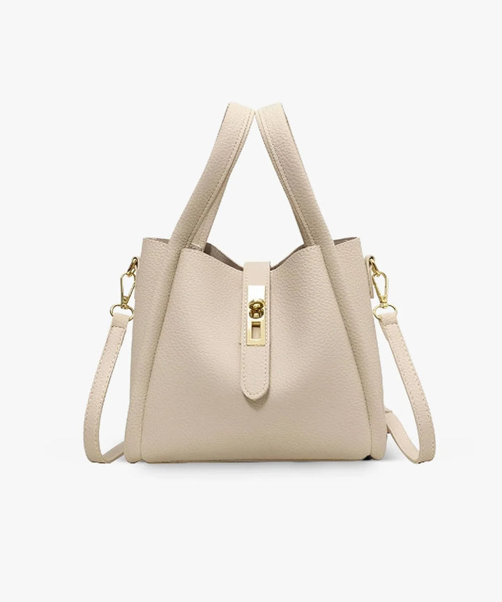 Front view of the Valeria vegan leather handbag in a light cream with gold turn-lock clasp and top handles