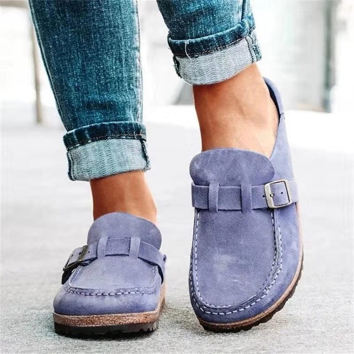 Worn by model of blue suede loafers with buckle and white stitching detail, paired with cuffed jeans