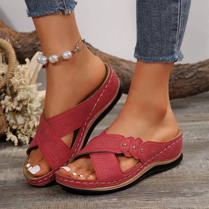 Front view of a model wearing red Gabrielle Summer Slides with white nails and a pearl anklet
