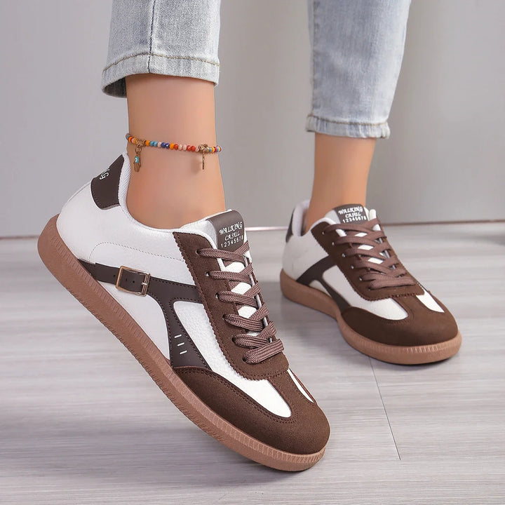 Close up of Luna soft-soled casual sneakers with white and brown panels worn by model