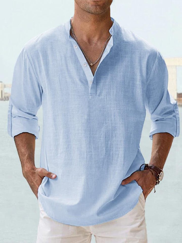 Front view of a man wearing a light blue breathable cotton shirt with a Henley collar and rolled up sleeves