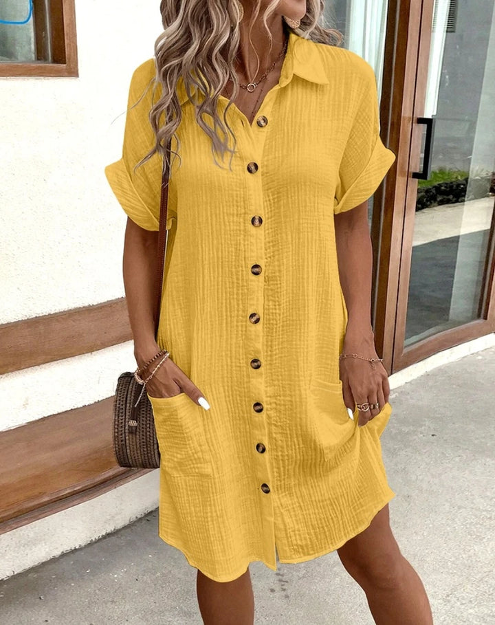 Front view of a model in a yellow vintage cotton-linen mini dress with a button-down front and side pockets