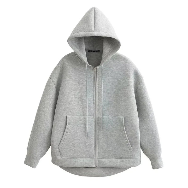 Front view of a light grey oversized full zip hoodie with hood up and pockets visible, on a hanger