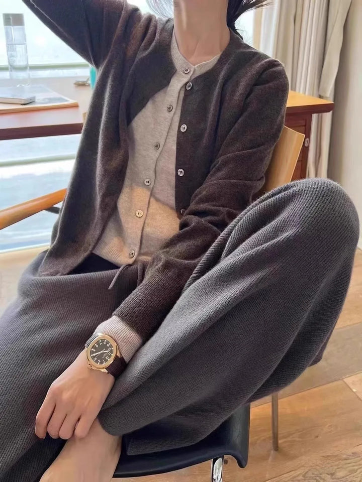 Front view worn by model, a dark grey cashmere cardigan over a light grey top and matching knit pants