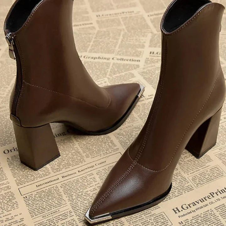 Back and three quarter view of two brown leather Chelsea boots with chrome-tipped pointed toes and block heels
