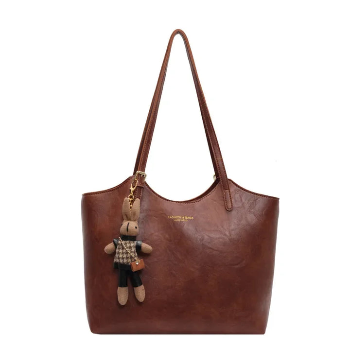 Front view of the Piper vegan leather tote bag in dark brown with a cute bunny charm and subtle branding