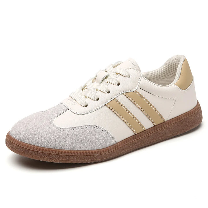 Side view of a single classic black and white casual sneaker with tan stripes and a brown sole