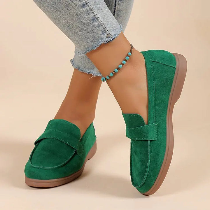 Back view worn by model, green suede loafers with brown soles, light blue jeans, and a turquoise anklet