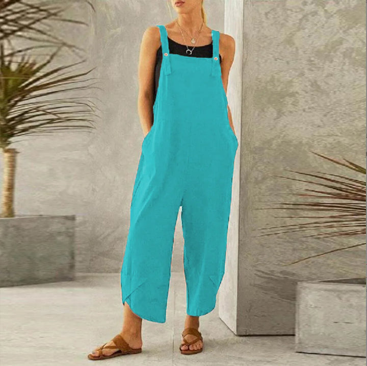 Front view of a model wearing the bright blue Isla oversized cotton-linen summer overalls with a black top