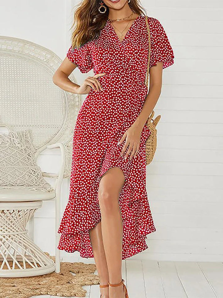 Front view of model in an elegant boho floral chiffon maxi dress with a ruffled high low hem and side split
