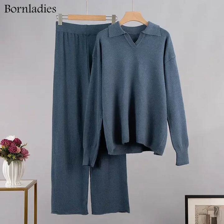 Flat lay of a blue cozy knitted two-piece set, featuring a polo neck sweater and wide-leg pants on hangers