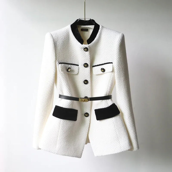 Front view of the Hazel wool coat, a white tailored jacket with black velvet trim and a thin black belt