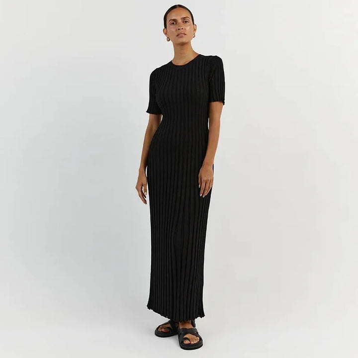 Front view, model wearing a black ribbed knit short sleeve maxi dress with sandals