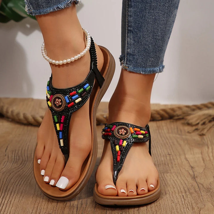 Black beaded clip toe gladiator sandals worn with cuffed blue jeans