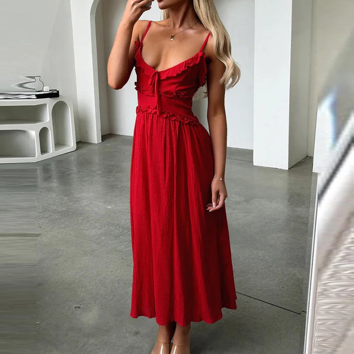 Front view, model wearing a red pleated V-neck beach dress with ruffled trim and ankle length A-line skirt