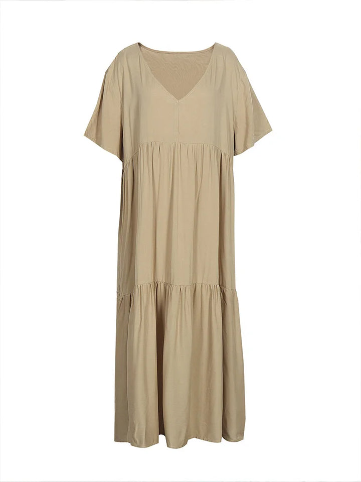 Flat lay of a plus size V-neck midi dress in beige with pleated detail and short sleeves