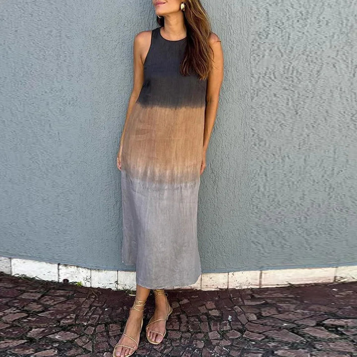 Side view of a model wearing a sleeveless black, brown and grey ombre Boho print dress with sandals